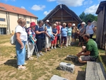 Na obrázku naše skupina stojící kolem průvodce pana Aleše, který zrovna ukazuje, jak se opracovávaly nástroje v dávných dobách