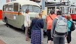 Skupinka členů před autobusem Praga naslouchá výkladu Skupinka členů před autobusem Praga naslouchá výkladu