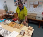 Návštěvník si prohlíží společenské hry pro nevidomé a slabozraké.