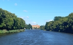 Pohled z lodě přes řeku Labe na zámek, po stranách jsou vidět zelení zarostlé břehy. Pohled z lodě přes řeku Labe na zámek, po stranách jsou vidět zelení zarostlé břehy.