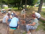 Naše celá parta okolo ohýnku a opékáme buřty.
