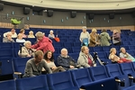 Na obrázku interiér kina a diváci – někteří v sedačkách ještě zpracovávají promítnutý film, někteří již pomalu odcházejí. Na obrázku interiér kina a diváci – někteří v sedačkách ještě zpracovávají promítnutý film, někteří již pomalu odcházejí.