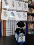 Psí kasička v knihovně s obrázky dětí