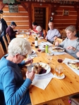 3 Členové SONS sedí u stolu v restauraci U Poláků a jedí svatomartinskou husu