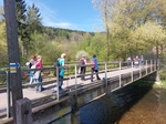 skupina turistů přecházející most nad řekou