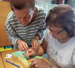 Naše pracovnice pomáhá při práci jedné z účastnic tvoření.