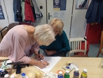 Lektorka pomáhá s jemnými pracemi při dokončování namalovaného obrázku jedné z našich klientek.