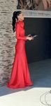 Moderátorka módní přehlídky v červených dlouhých šatech