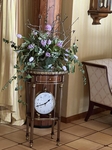 Na fotografii je hodinový stolek s květinovou dekorací 